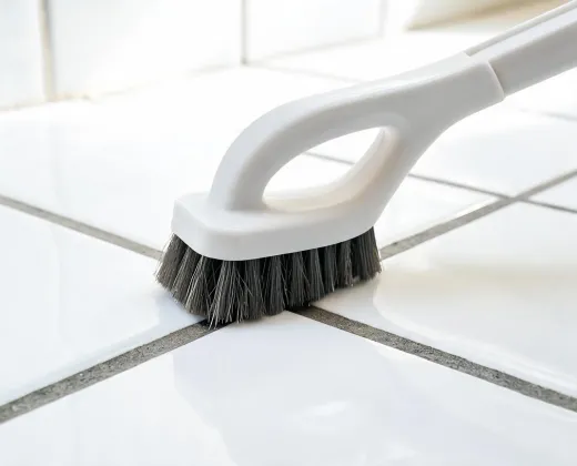 Scrub brush near tile grout
